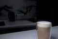 Cup of coffee in a double-botoom glass on white table in gray kitchen