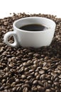 Cup of coffee drink sitting on a bed of roasted coffee beans background. Royalty Free Stock Photo