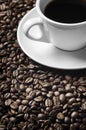 Cup of coffee drink sitting on a bed of roasted coffee beans background. Royalty Free Stock Photo