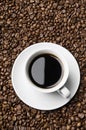 Cup of coffee drink sitting on a bed of roasted coffee beans background. Royalty Free Stock Photo