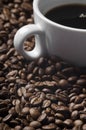 Cup of coffee drink sitting on a bed of roasted coffee beans background. Royalty Free Stock Photo