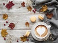 Cup of coffee and dry leaves on white wooden background Royalty Free Stock Photo
