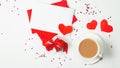 Cup of coffee with envelope with blank note mockup, red paper hearts, gift box on white background for Valentine`s Day greeting Royalty Free Stock Photo