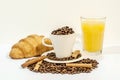 Cup of coffee filled with coffee beans with croissants, cinnamon stick Royalty Free Stock Photo