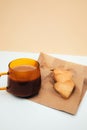 A cup of coffee with foam and a plate with heart-shaped shortbread cookies on a paper bag Royalty Free Stock Photo