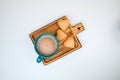 A cup of coffee with foam and a plate with heart-shaped shortbread cookies on a white background Royalty Free Stock Photo