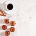 A cup of coffee and French dessert canele on grey background