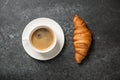 Cup of coffee and fresh croissant on black table Royalty Free Stock Photo