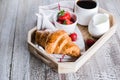 Cup of coffee, freshly baked croissants and fresh strawberry on wooden tray. Breakfast concept Royalty Free Stock Photo