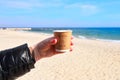 Woman hand with a cup of coffee in front of Black Sea in Odessa, Ukraine Royalty Free Stock Photo