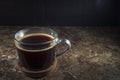 Cup of coffee with fume on the wooden background