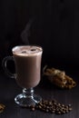 Cup of cacao. glass of hot chocolate with whipped cream, coffee beans and cinnamon sticks on a dark background. Royalty Free Stock Photo