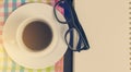 Cup of coffee with glasses and book page. Royalty Free Stock Photo