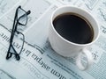 A cup of coffee, glasses and a newspaper Royalty Free Stock Photo