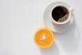 Cup of coffee and half of orange fruit on white background. Top view, copy space. Morning espresso on table. Healthy breakfast. Royalty Free Stock Photo