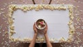 Cup of coffee in hands on table. Rose petals. Flatlay