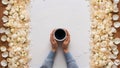 Cup of coffee in hands on table. Rose petals. Flatlay