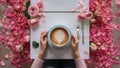 Cup of coffee in hands on table. Rose petals. Flatlay