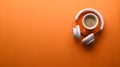 Cup of coffee, headphone and copy space on orange background.