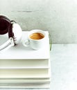 A cup of coffee and headphones on a stack of books Royalty Free Stock Photo