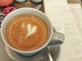 A cup of coffee with heart decoration at table