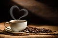 Cup of coffee with heart shape smoke and coffee beans on burlap sack on old wooden background Royalty Free Stock Photo