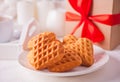 Cup of coffee and a heart shaped cookies on the white plate with gift box on the white table Royalty Free Stock Photo