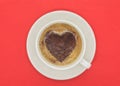 Cup of coffee with heart shaped pattern on red background. Royalty Free Stock Photo