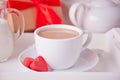 Cup of coffee and a heart shaped red chocolate candies with gift box on the white table Royalty Free Stock Photo