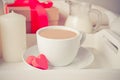 Cup of coffee and a heart shaped red chocolate candies with gift box on the white tray Royalty Free Stock Photo