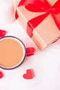 Cup of coffee and a heart shaped red cookie with gift box on the white table Royalty Free Stock Photo
