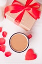 Cup of coffee and a heart shaped red cookie with gift box on the white table Royalty Free Stock Photo