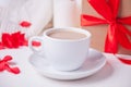 Cup of coffee and a heart shaped red cookie with gift box on the white table Royalty Free Stock Photo