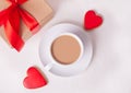 Cup of coffee and a heart shaped red cookies with gift box on the white table Royalty Free Stock Photo