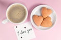 Cup of coffee, homemade heart-shaped cookies and a note with the words I love you on pastel pink color. Valentine`s Day breakfast Royalty Free Stock Photo