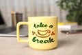 Cup of coffee with inscription Take a Break on wooden table in office Royalty Free Stock Photo