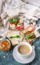 Cup of coffee, Italian toasts with cheese, tomatoes, basil, quail eggs. Still life of tasty and healthy breakfast. Vertical shot