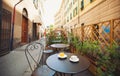 A cup of coffee and juice on table, in italian street, mediterranean style. Street view of a summer terrace