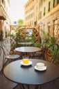 A cup of coffee and juice on table, in italian street, mediterranean style. Street view of a summer terrace