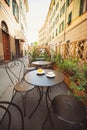 A cup of coffee and juice on table, in italian street, mediterranean style. Street view of a summer terrace