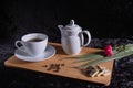 A cup of coffee and a kettle stand on a tray