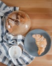A cup of coffee on a kitchen towel and a croissant on a plate Royalty Free Stock Photo