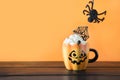 Cup of coffee latte garnish spider web and coming black spider. Halloween holiday treat