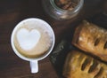 Cup of coffee with latte heart. Delicious and creative breakfast with coffee and buns.