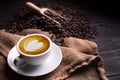 Cup of coffee latte with heart shape and coffee beans on old wooden background Royalty Free Stock Photo