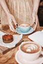 Cup of coffee latte and sweet pastry on wooden table in woman hands. Gentle romantic mood, girl wearing pink skirt Royalty Free Stock Photo