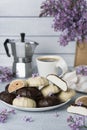 Cup of coffee, lilac, marshmallow in dark and white chocolate glaze, coffee maker. Still life