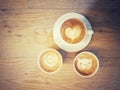 Cup of coffee with a lot of beautiful latte art on wooden table with vintage style Royalty Free Stock Photo