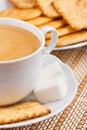 A cup of coffee with a lump sugar and crackers Royalty Free Stock Photo