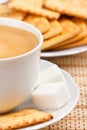 A cup of coffee with a lump sugar and crackers Royalty Free Stock Photo